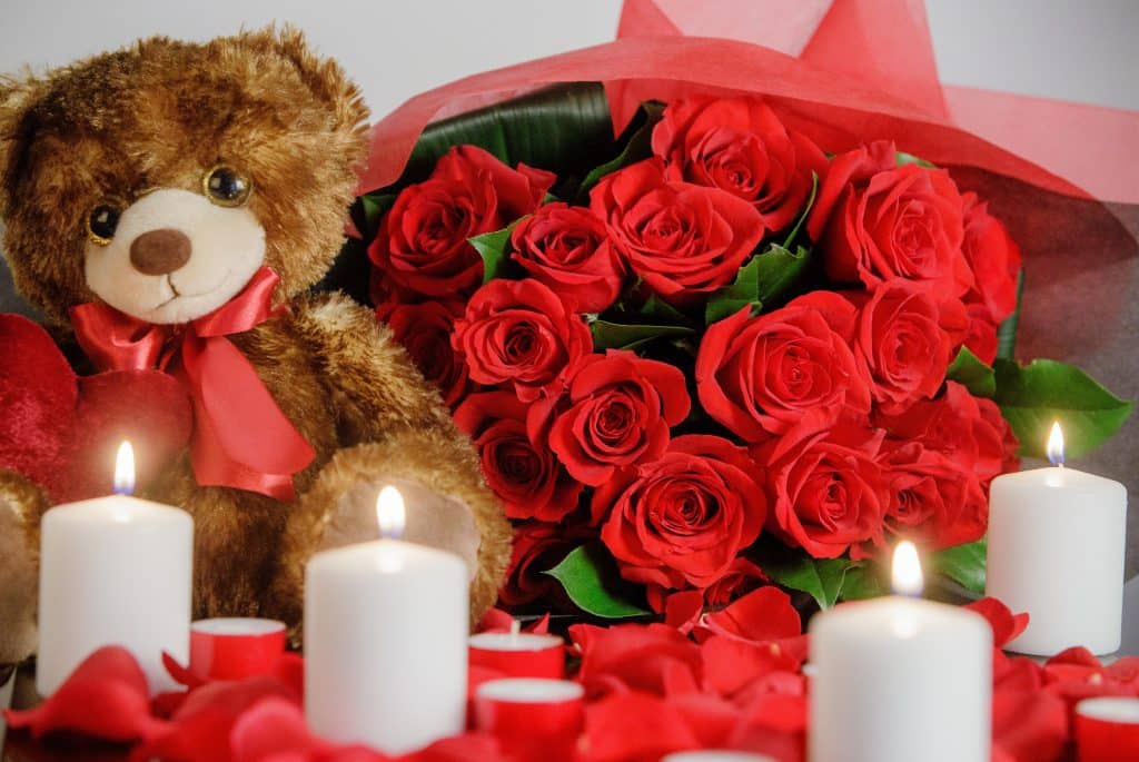 Set the mood for a romantic night together, with roses, petals, candles, and the sweetest teddy